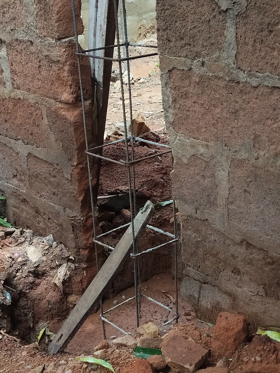 Reinforcement for a small column with closed ties around the main bars, standing in a foundation pit