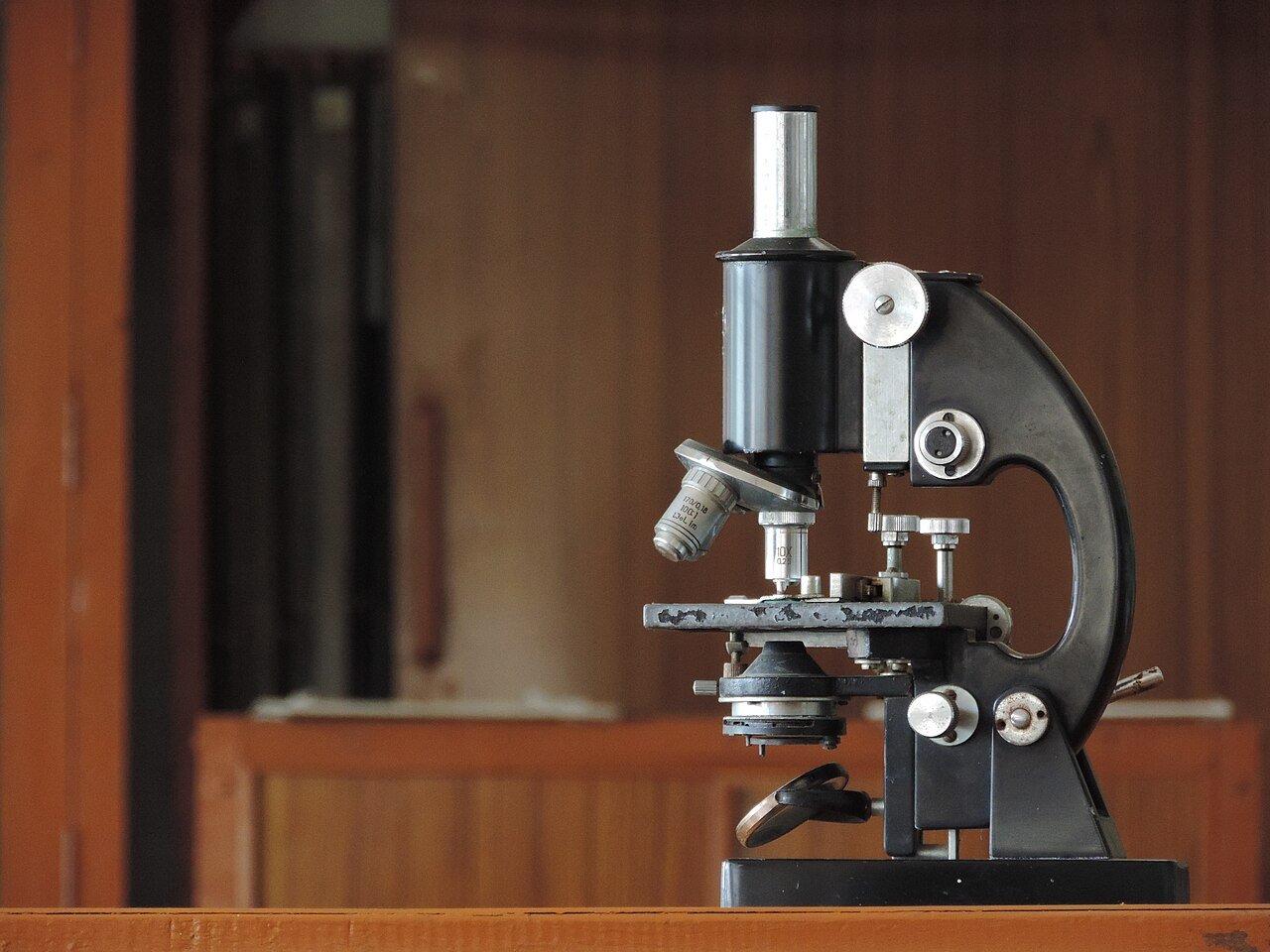 Compound light microscope standing on a bench
