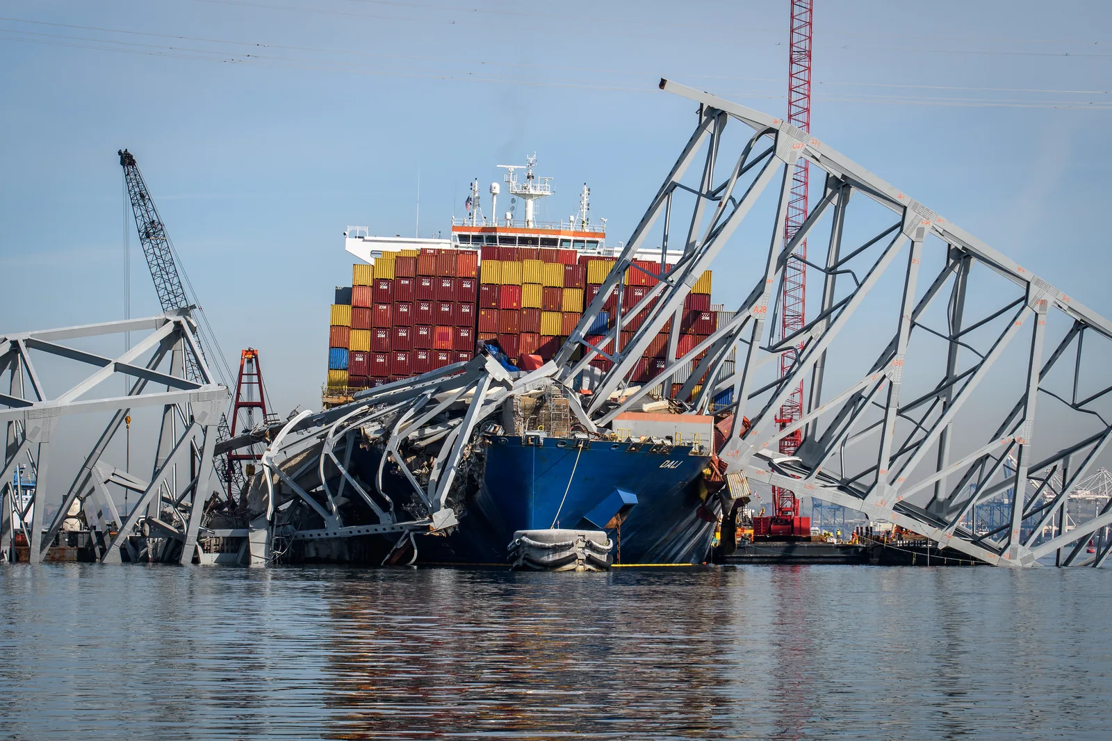 The bow of the container ship Dali pinned under fallen steel truss sections of the Key Bridge during salvage
