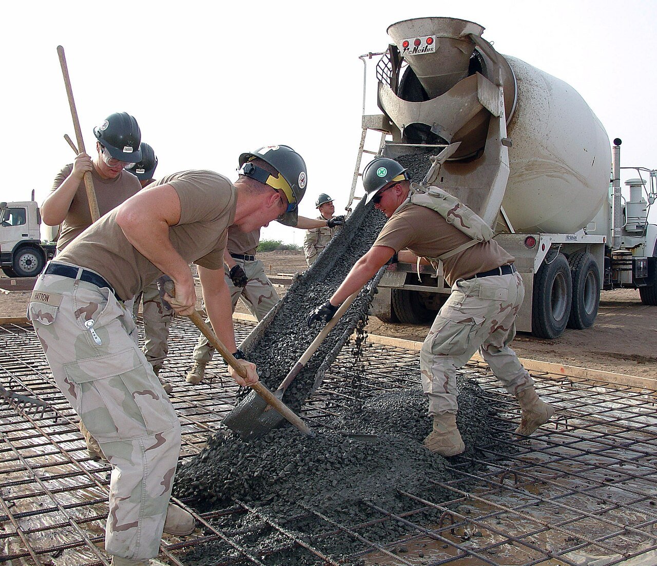 Workers placing concrete for a pad from a truck chute